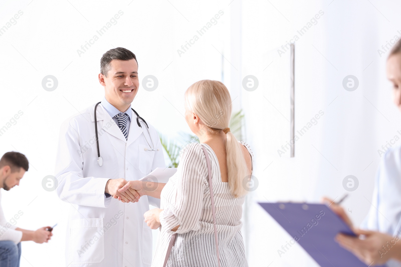 Photo of Doctor and patient shaking hands in hospital hall