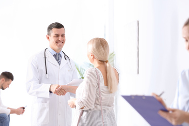 Photo of Doctor and patient shaking hands in hospital hall