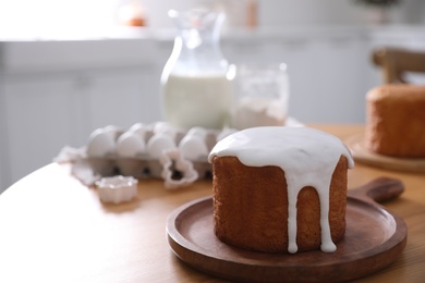 Photo of Traditional Easter cake on wooden table in kitchen, space for text