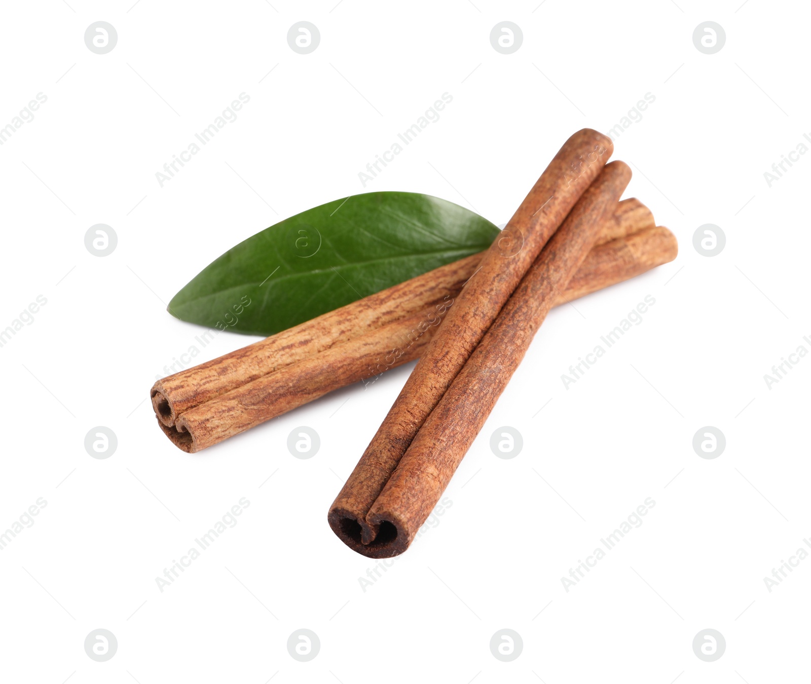 Photo of Cinnamon sticks and green leaf isolated on white