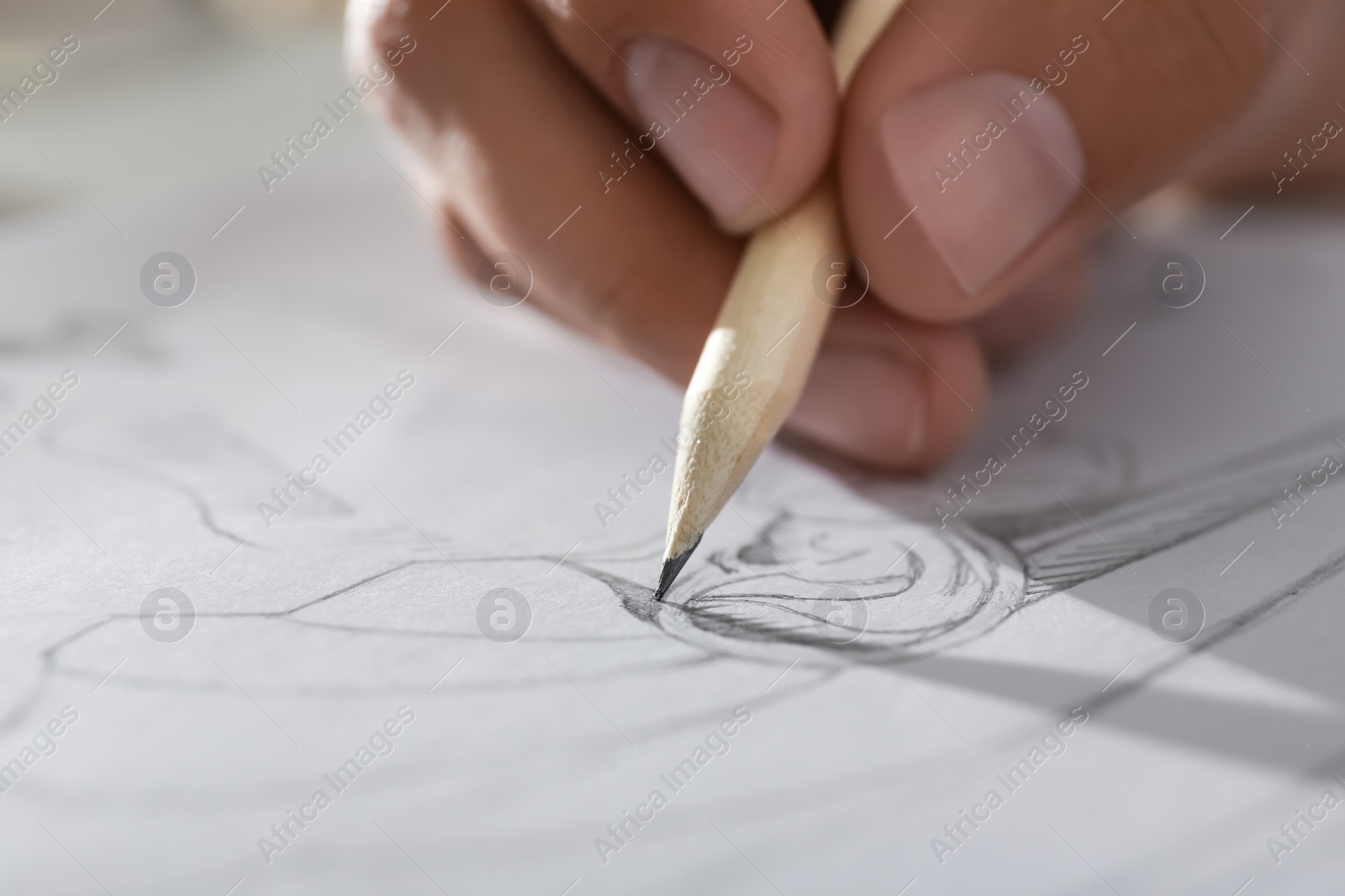 Photo of Man drawing portrait with pencil in notepad, closeup