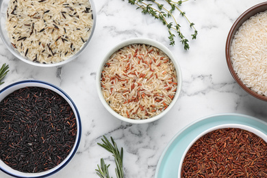 Photo of Flat lay composition with brown rice on marble table