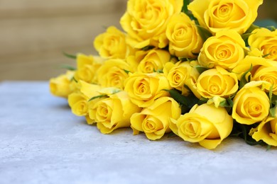 Beautiful bouquet of yellow roses on light table, selective focus. Space for text