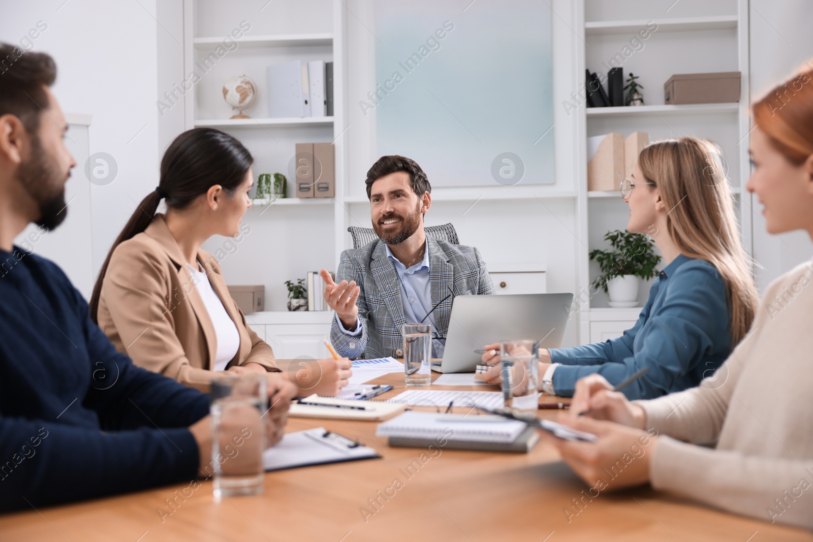 Photo of Team of employees working together in office