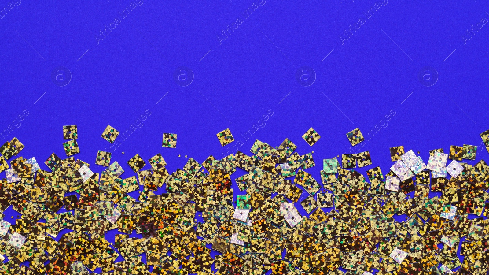 Photo of Many golden sequins on blue background, top view. Space for text