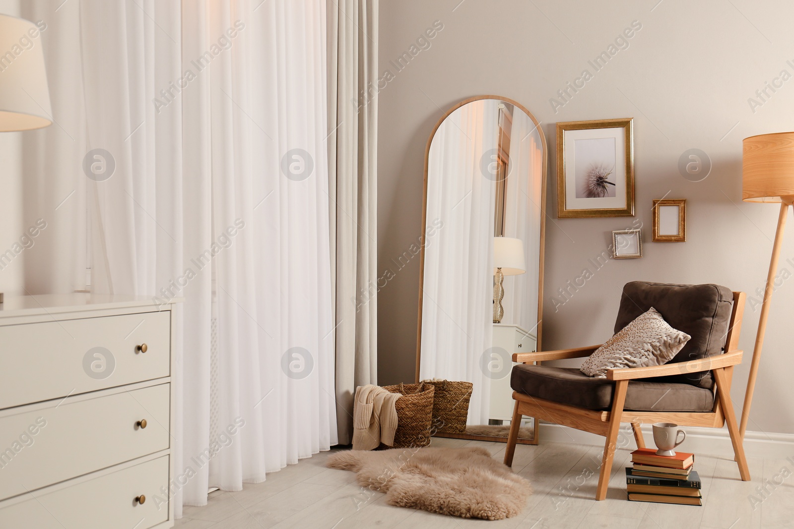 Photo of Stylish room interior with large mirror and comfortable armchair near window