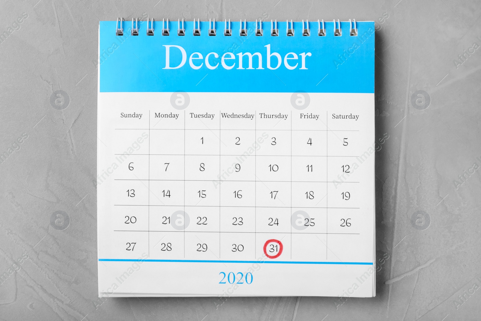 Photo of Calendar with marked date on grey stone table, top view. New Year countdown