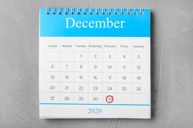 Calendar with marked date on grey stone table, top view. New Year countdown