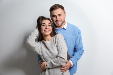 Photo of Young couple in warm sweaters on white background