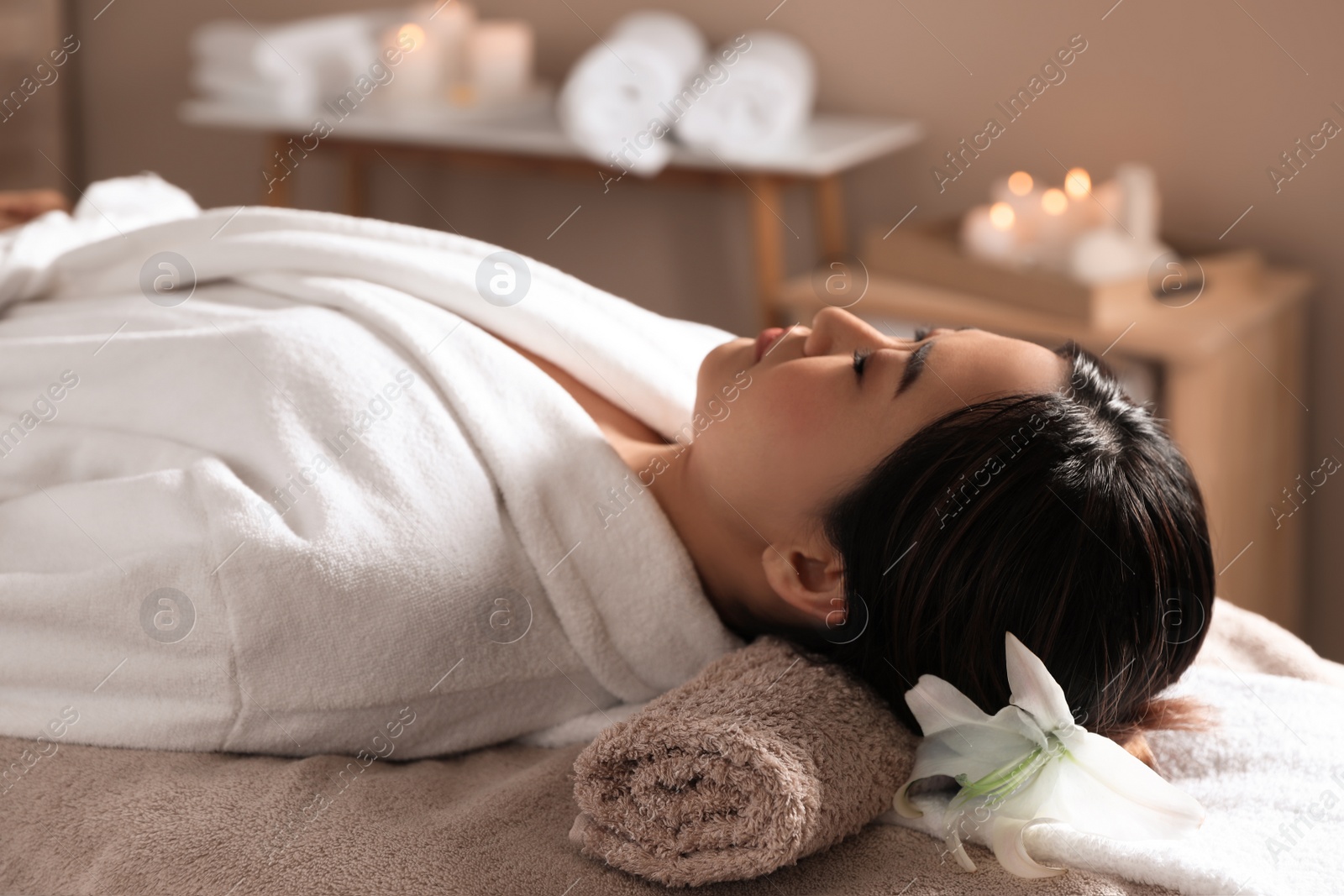 Photo of Beautiful Asian woman lying on massage table in spa salon