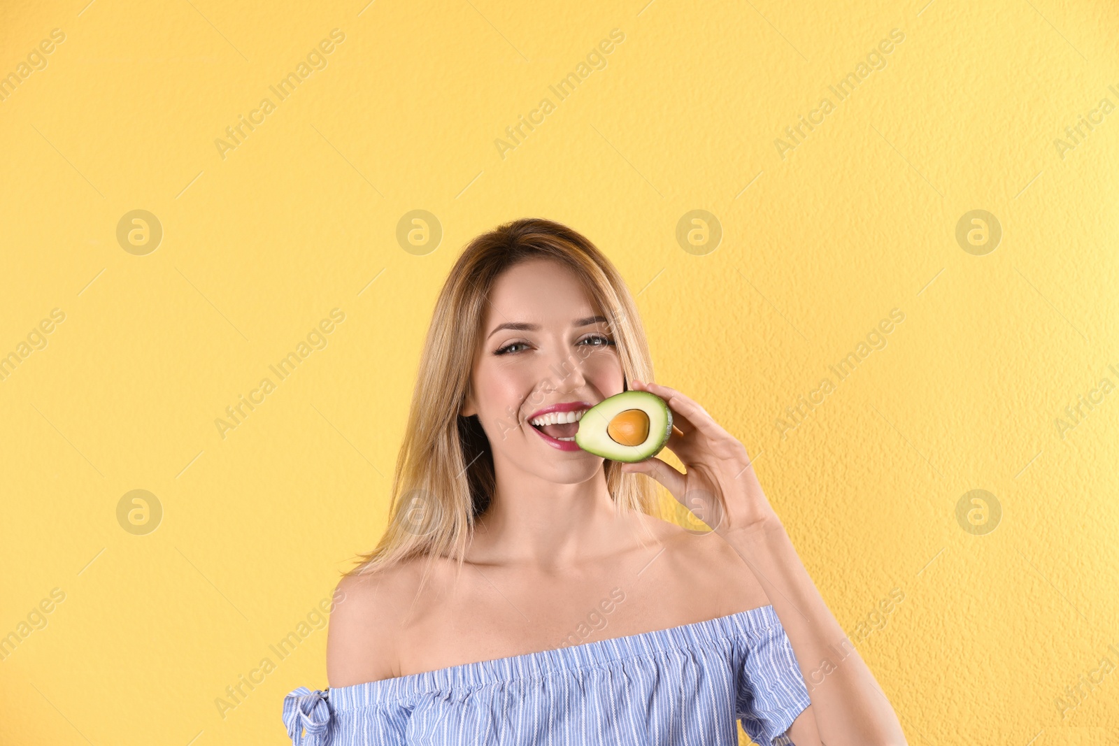 Photo of Portrait of young beautiful woman with ripe delicious avocado on color background