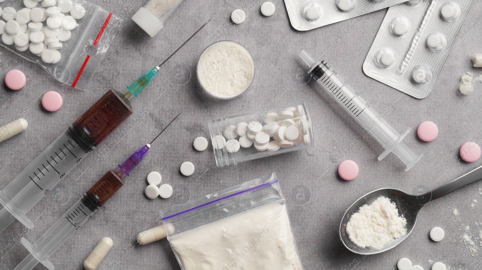 Photo of Different hard drugs on grey table, flat lay