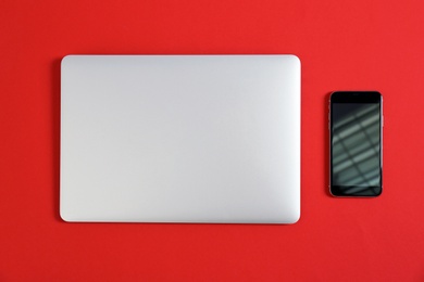 Photo of Modern laptop and mobile phone on color background, top view