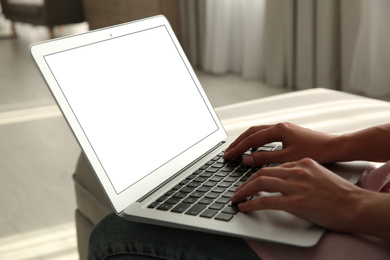 Woman working with modern laptop indoors, closeup