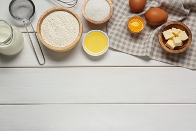Photo of Ingredients for crepes on white wooden table, flat lay. Space for text
