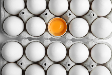 Photo of Many fresh raw chicken eggs in cartons as background, top view