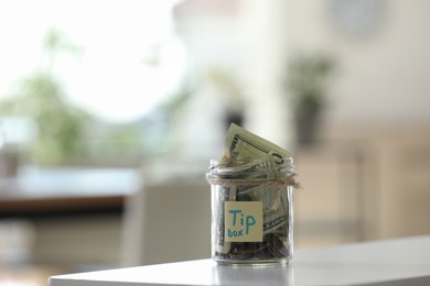 Photo of Glass jar with tips on table indoors. Space for text