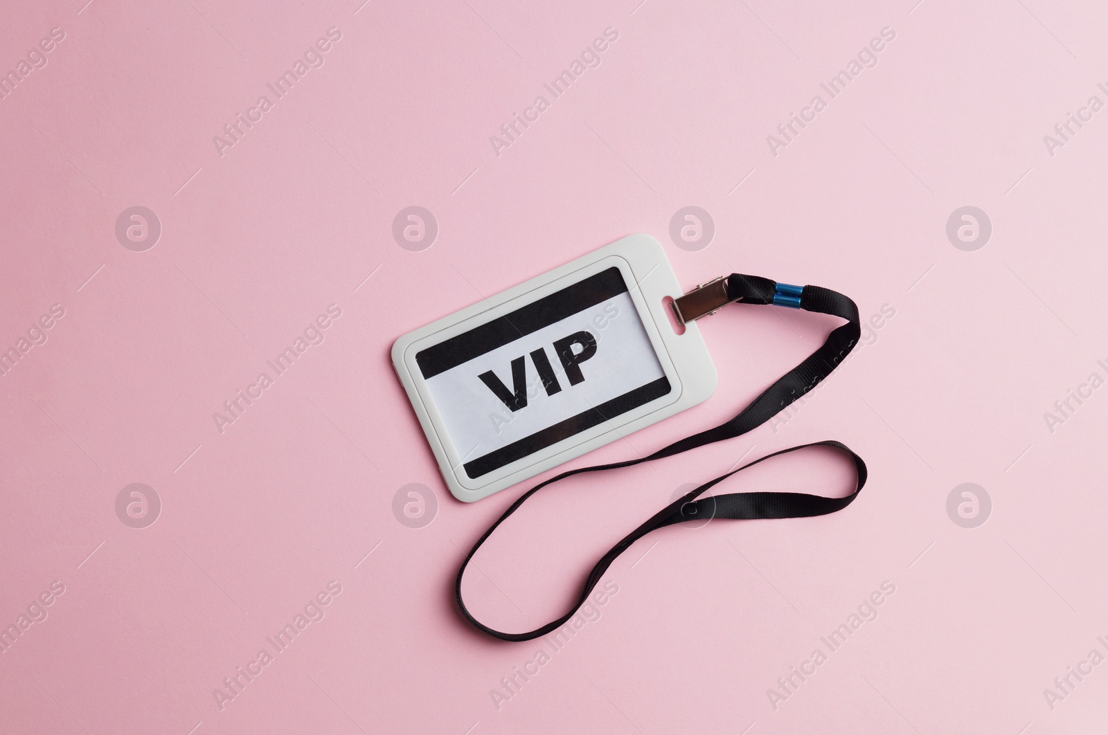 Photo of Plastic vip badge on pale pink background, top view