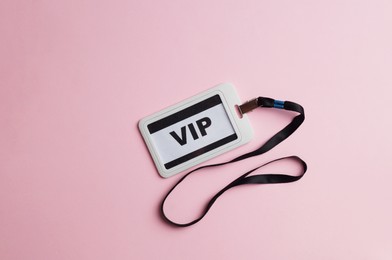 Plastic vip badge on pale pink background, top view