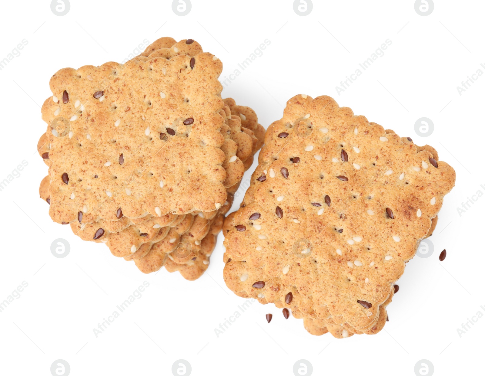 Photo of Stacks of cereal crackers with flax and sesame seeds isolated on white, top view