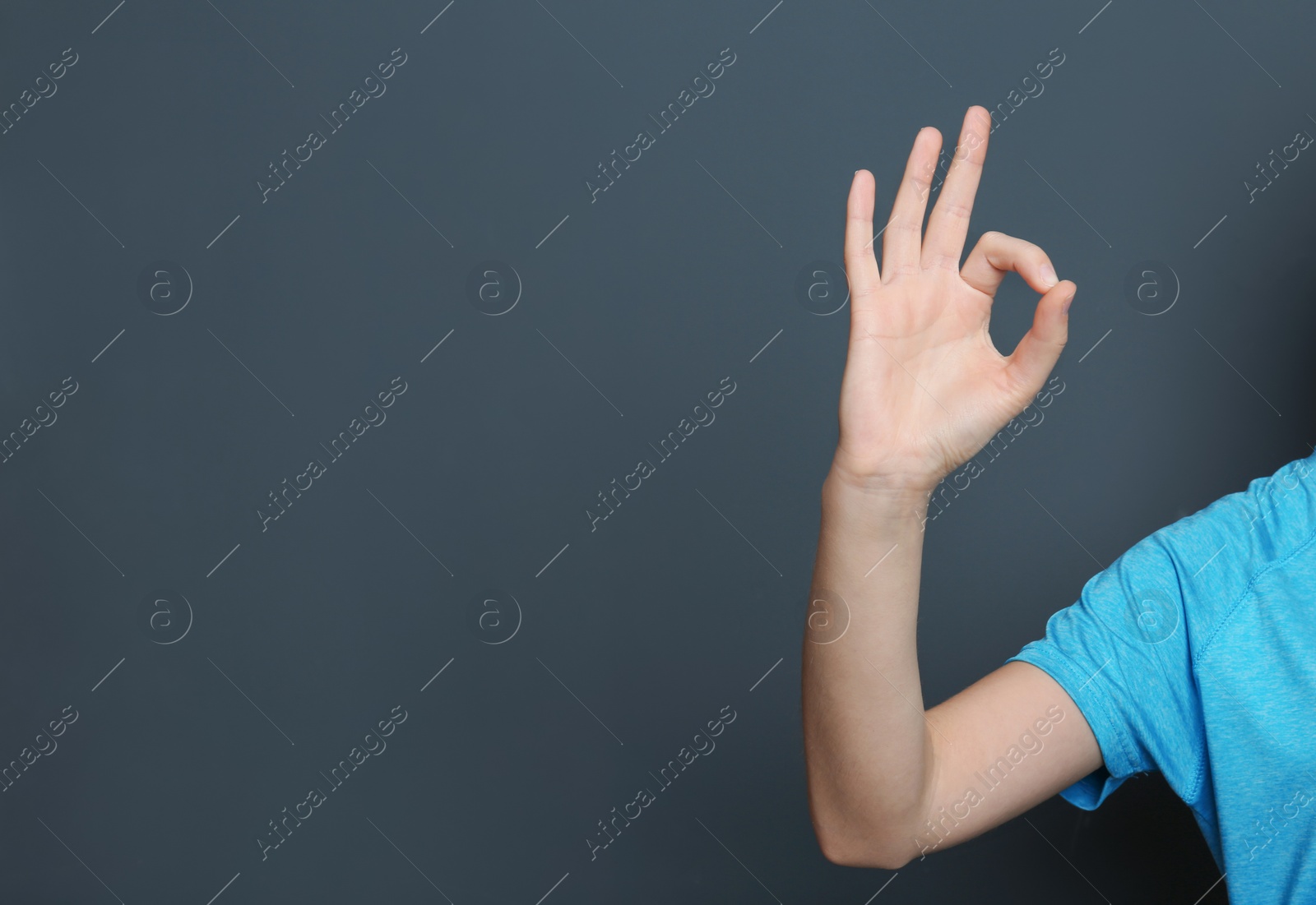 Photo of Young woman showing OK gesture on color background. Space for text