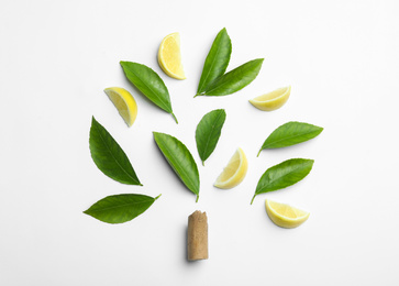 Composition with fresh green citrus leaves and lemon slices on white background, top view