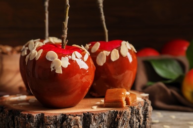 Delicious caramel apples on wooden serving board