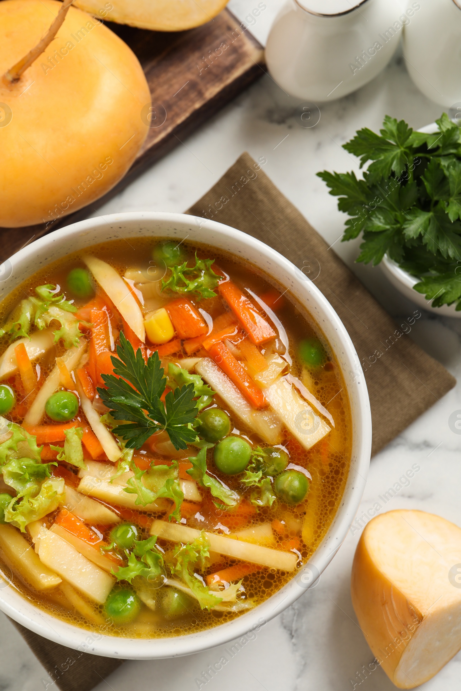 Photo of Bowl of delicious turnip soup on white marble table, flat lay