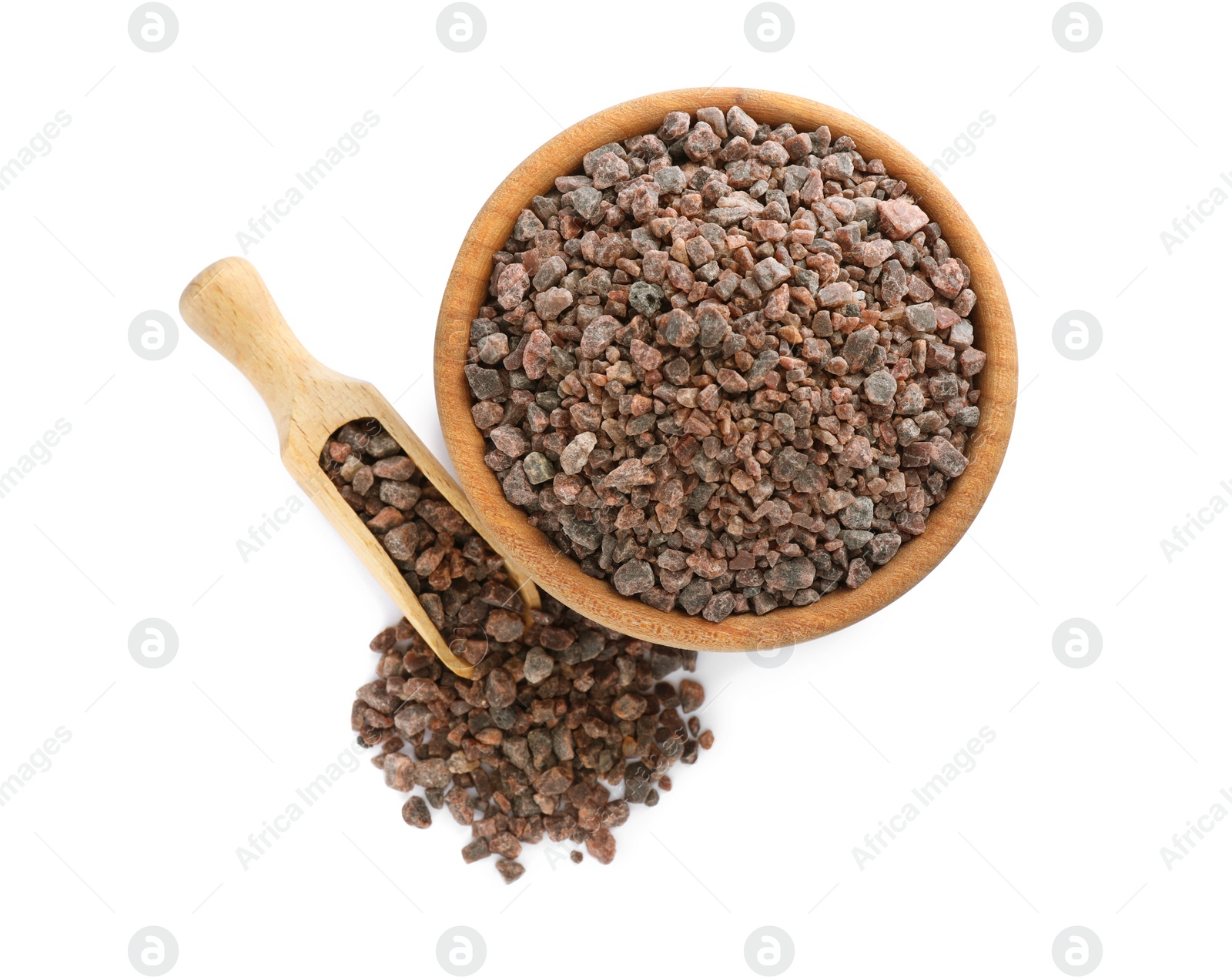 Photo of Wooden bowl and scoop with black salt on white background, top view