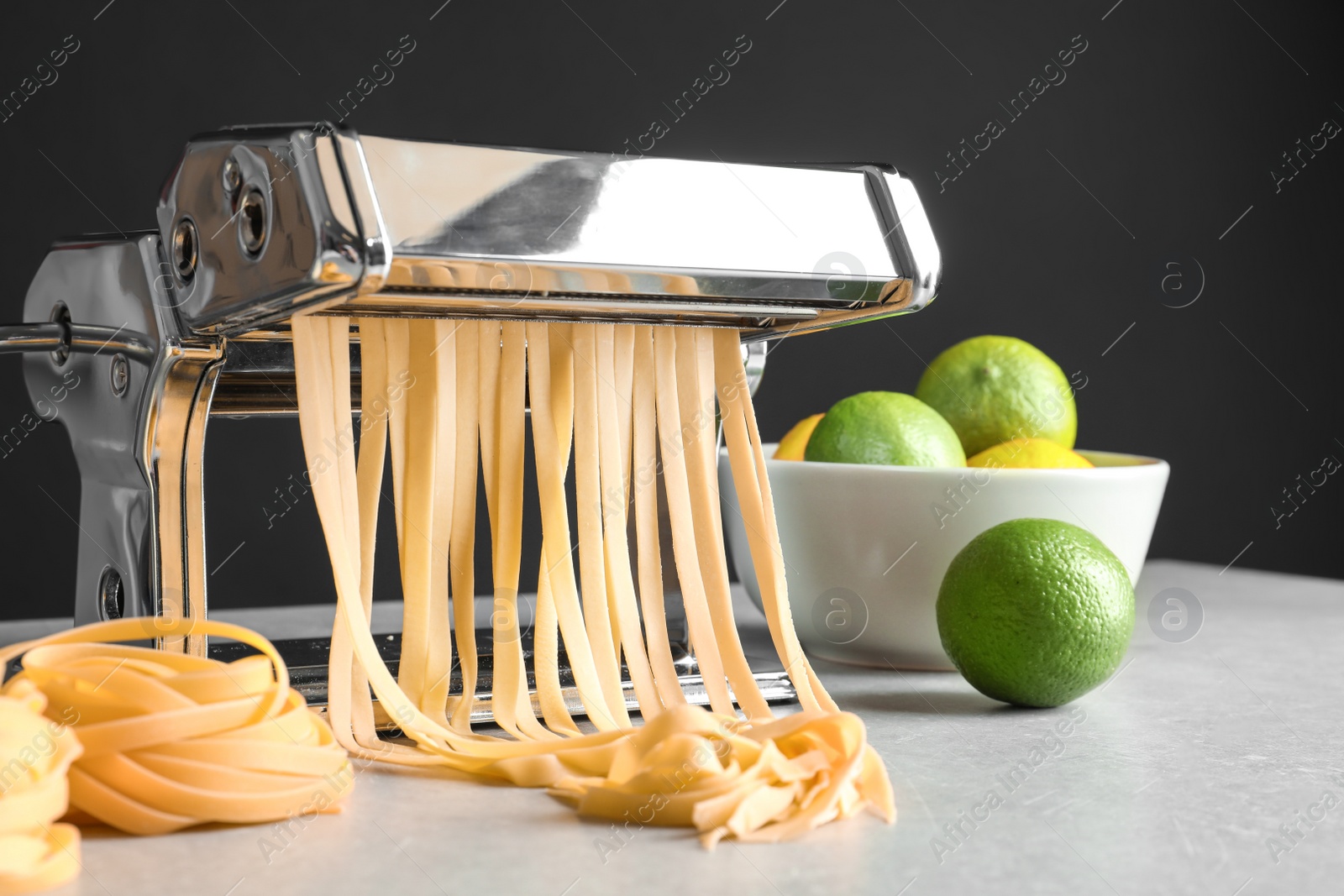 Photo of Pasta maker with dough on kitchen table