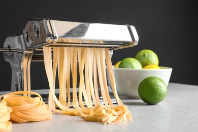 Photo of Pasta maker with dough on kitchen table