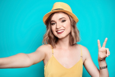 Photo of Beautiful young woman taking selfie on color background