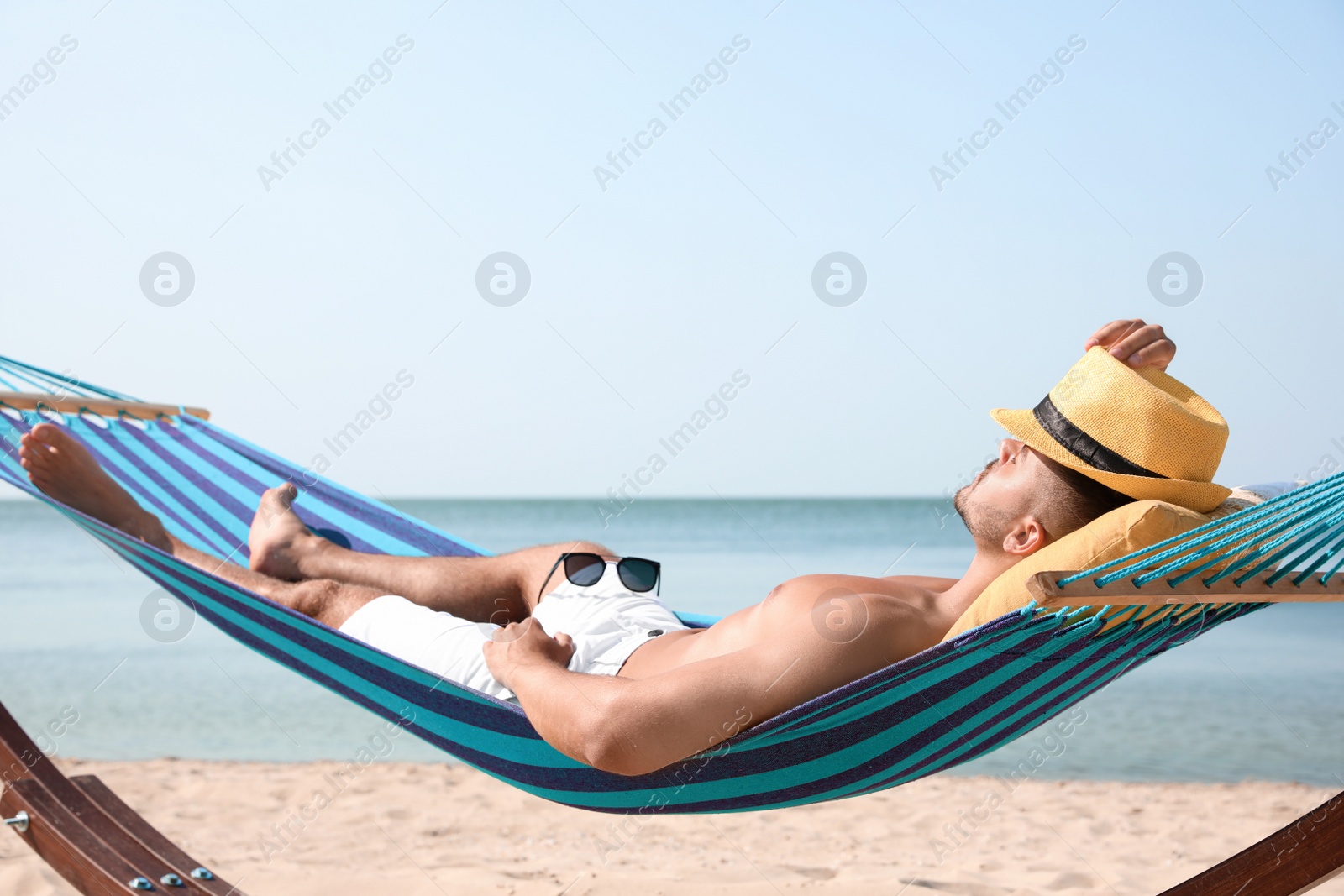 Photo of Young man relaxing in hammock on beach