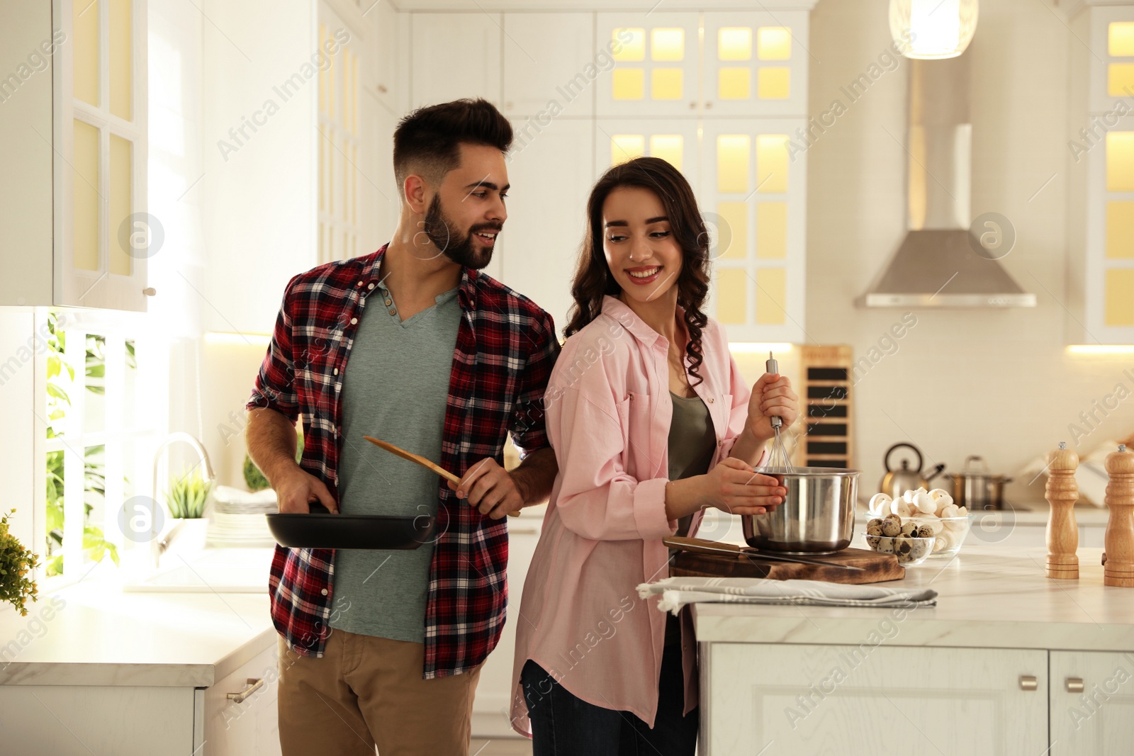 Photo of Lovely young couple cooking together in kitchen