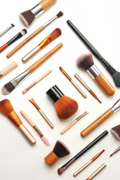 Flat lay composition with makeup brushes of professional artist on white background