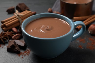 Photo of Yummy hot chocolate in cup on black table