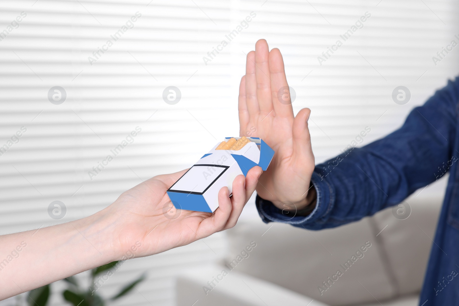 Photo of Woman refusing cigarettes at home, closeup. Quitting smoking concept