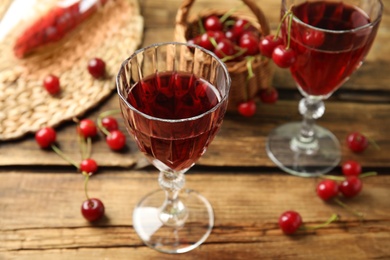 Delicious cherry wine with ripe juicy berries on wooden table