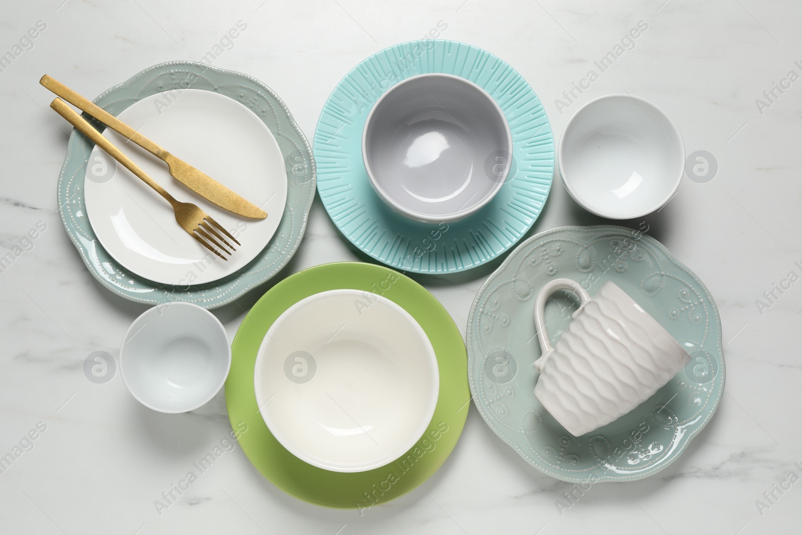 Photo of Beautiful ceramic dishware, cup and cutlery on white marble table, flat lay