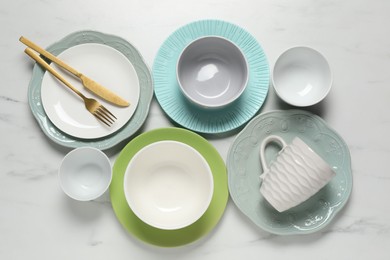 Photo of Beautiful ceramic dishware, cup and cutlery on white marble table, flat lay