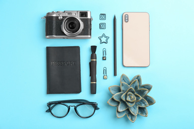 Photo of Flat lay composition with camera for professional photographer and smartphone on light blue background