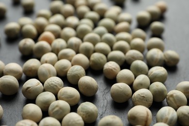 Photo of Raw dry peas on grey background, closeup. Vegetable seeds