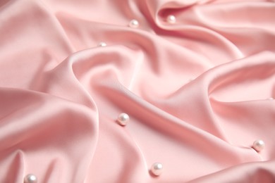 Photo of Many beautiful pearls on delicate pink silk