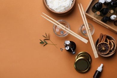 Photo of Flat lay composition with homemade candles ingredients on brown background, space for text