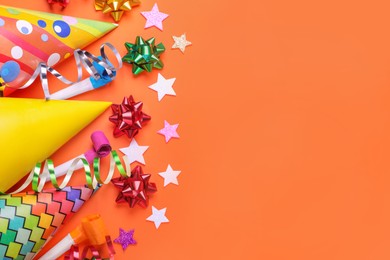 Photo of Flat lay composition with accessories for birthday party on orange background. Space for text