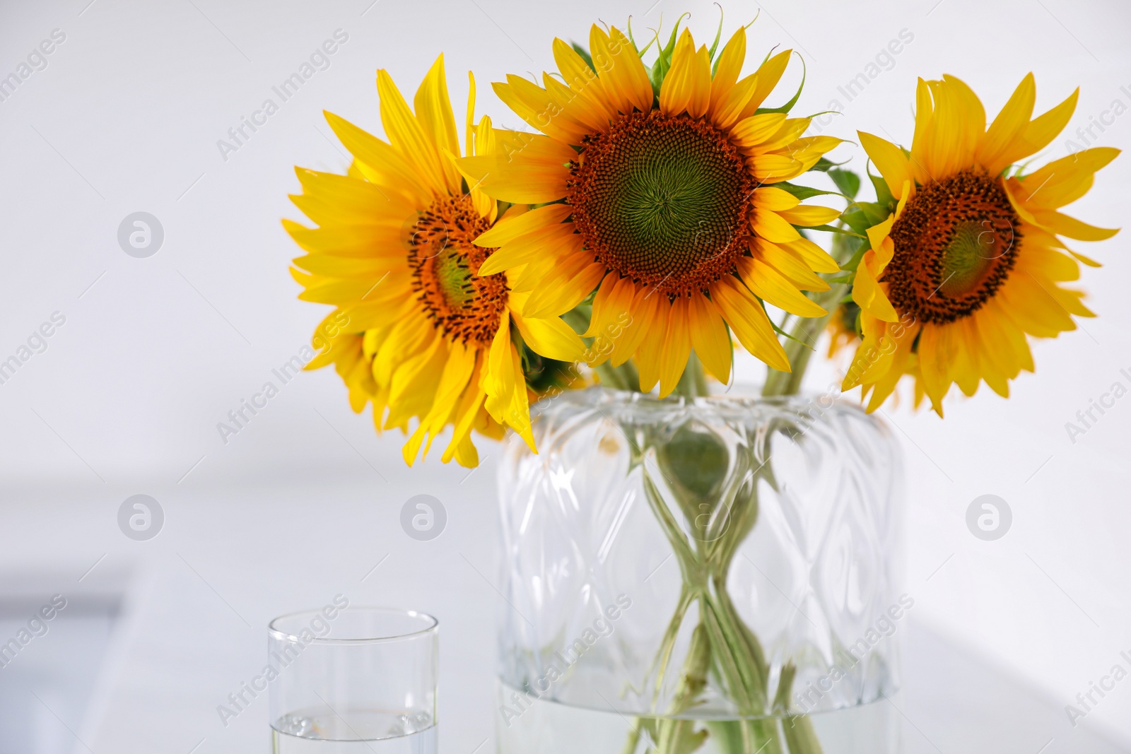 Photo of Beautiful bouquet of sunflowers in vase at home, closeup