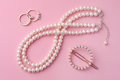 Photo of Elegant pearl jewelry on pink background, flat lay