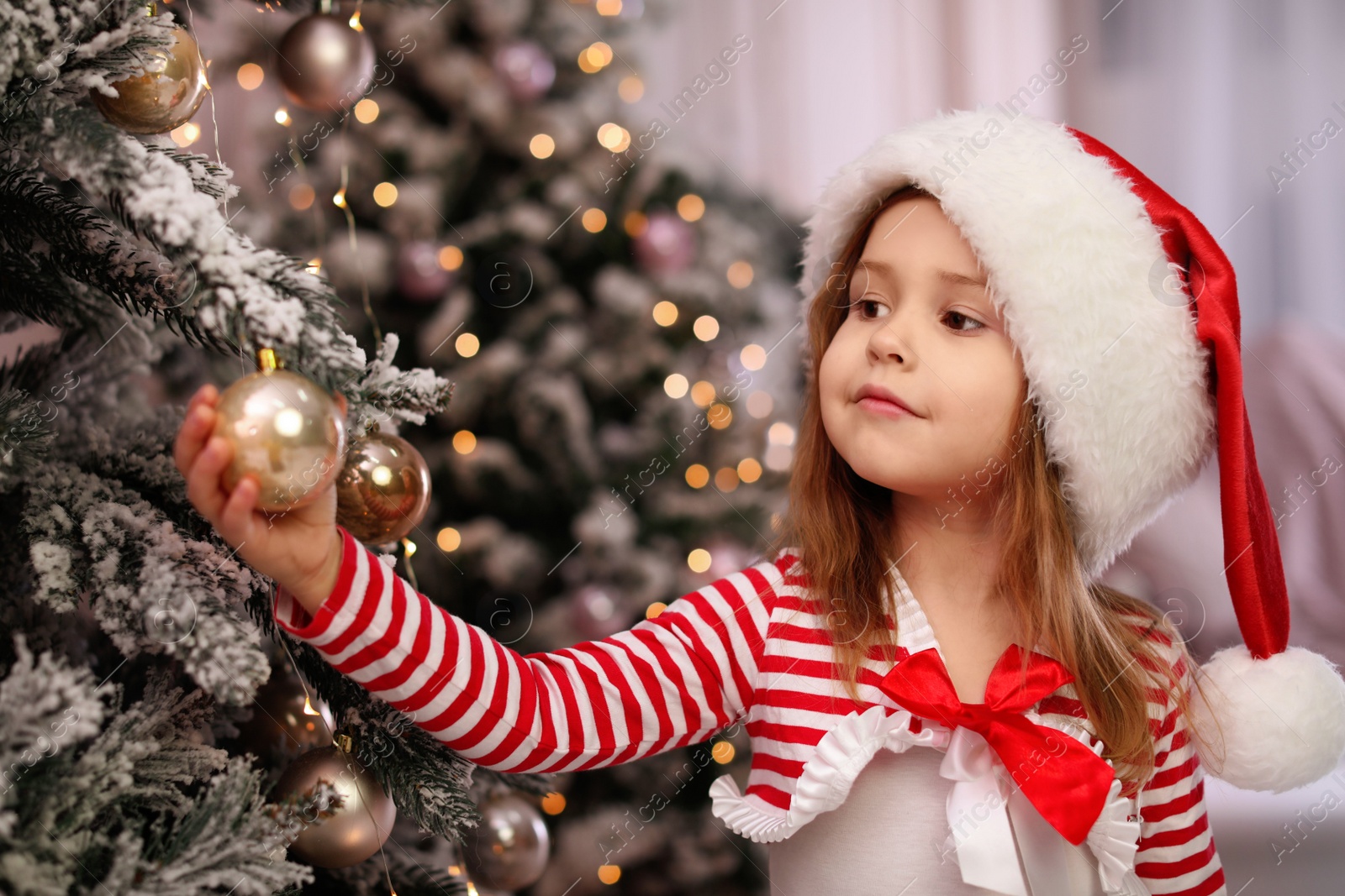 Photo of Cute little child near Christmas tree at home