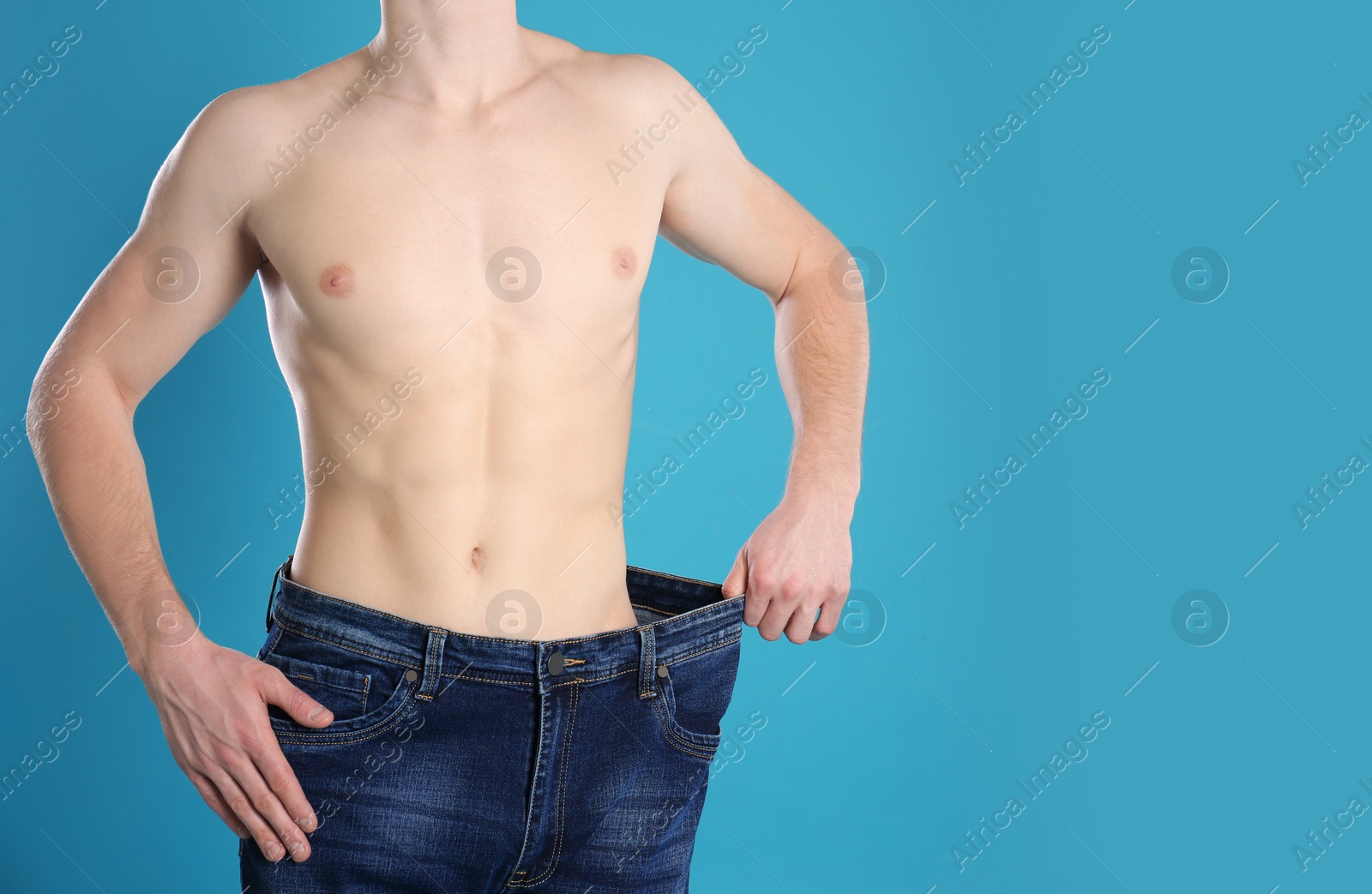 Photo of Young man in oversized jeans on color background, closeup. Space for text