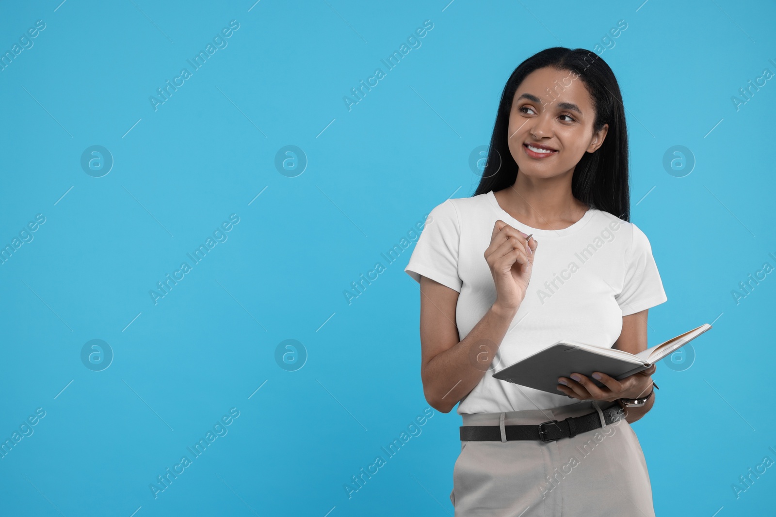 Photo of Beautiful secretary with notebook and pen on light blue background, space for text